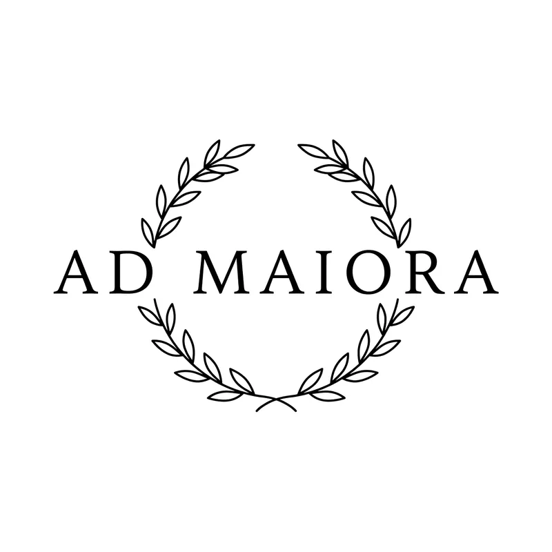 Tatuaggio scritta «Ad maiora» in maiuscole serif con corona d'alloro